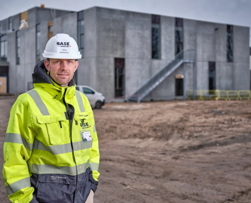 Professionelt erhvervsportræt fotograferet i autentiske rammer på arbejdspladsen.